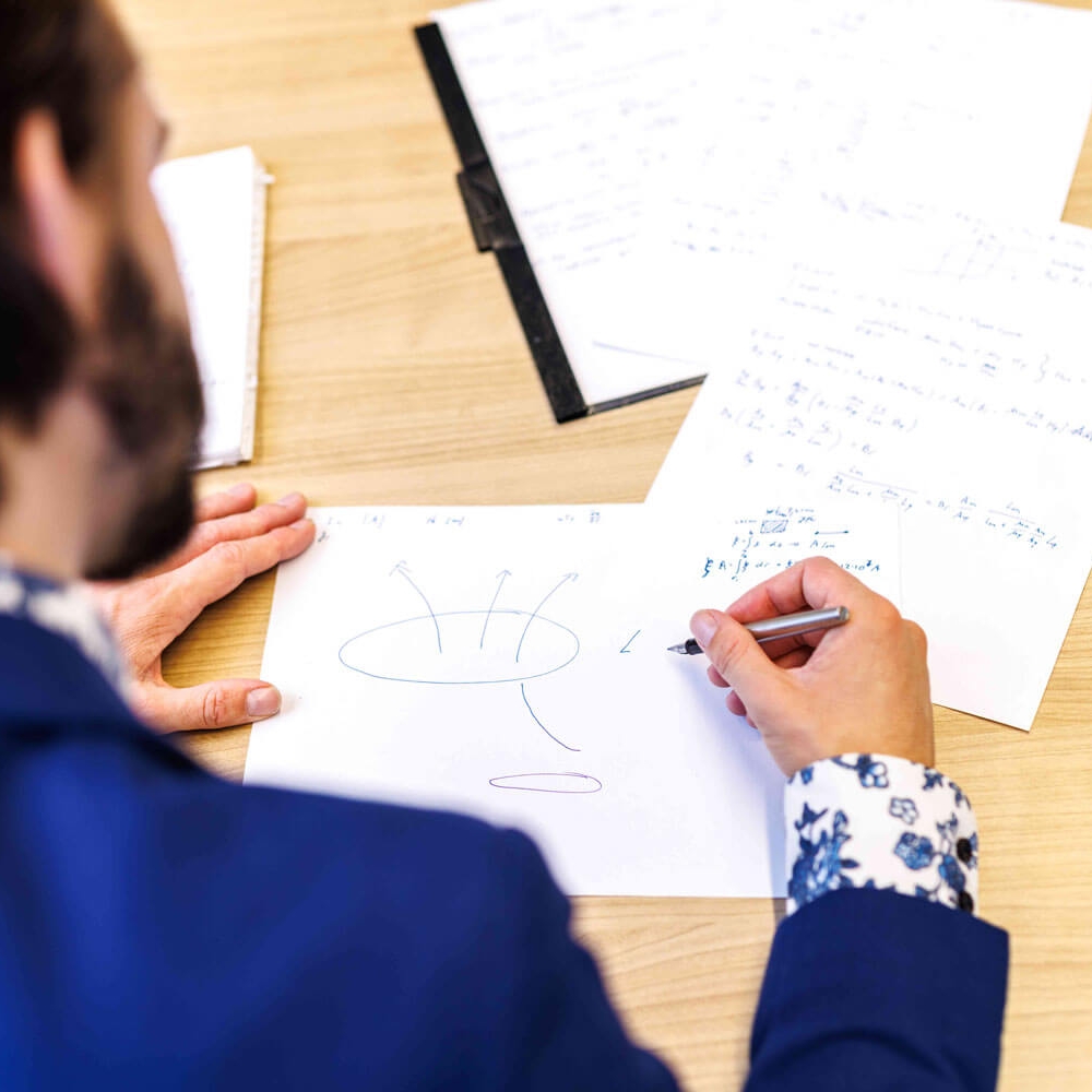 ingenieur die handberekeningen voor elektromagnetisme uitvoert 