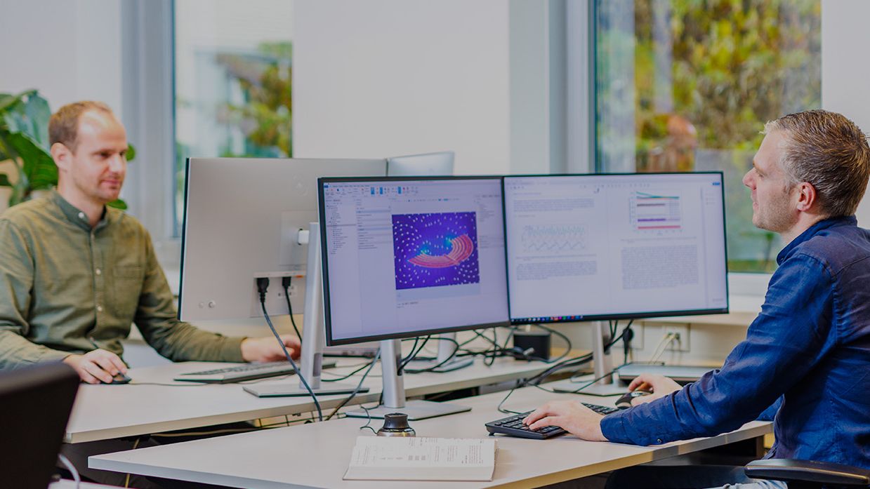 ingenieurs achter computers die werken aan FEM-simulaties