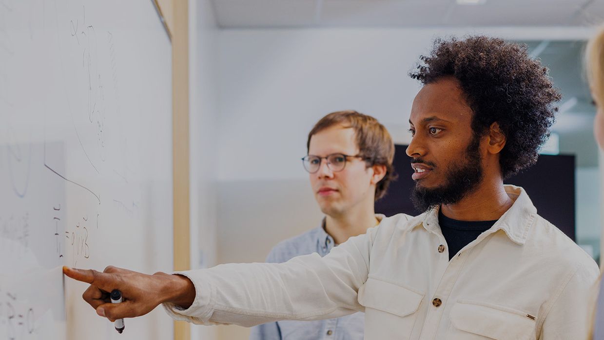 engineers discussing at whiteboard