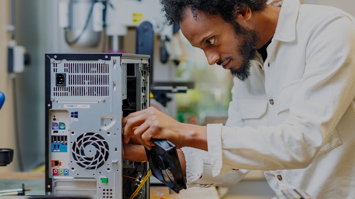man in lab working on fan system of a pc